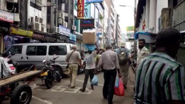 Teslimatçı, Kolombo, Sri Lanka 'nın işlek sokaklarında dolaşırken kafasında ağır kutular taşıyor.