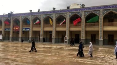 Şiraz, İran 'daki Şah Çerağ camisinin avlusunda yürüyen insanlar canlı kültürel atmosferi sergiliyorlar.