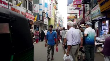 Turistler ve yerel halk, canlı dükkanlar ve sokak yemekleriyle dolu Colombo, Sri Lanka 'daki hareketli bir sokak pazarında geziniyorlar.