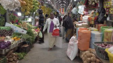 Kalabalık Sri Lanka 'da hareketli bir pazarı dolduruyor, taze ürünler alıyor ve canlı atmosferin tadını çıkarıyor.