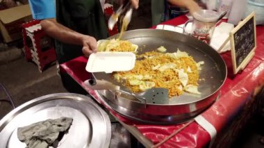 Sokak yemekleri satıcısı Phayao, Tayland 'da lezzetli bir şehriye yemeği hazırlıyor, otantik yerel tatlar ve aşçılık becerileri sergiliyor.