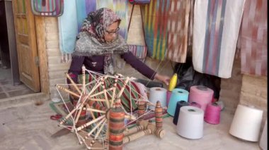 İranlı zanaatkar İsfahan 'da geleneksel bir tekerlek üzerinde iplik eğip zengin kültür mirası ve zanaatkarlığını sergiliyor.