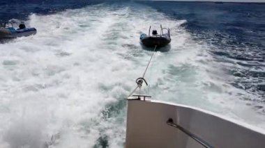 Galapagos Adaları 'nın güzel sularında yüzen ve göz kamaştırıcı manzarası olan iki çıkarma aracını çeken bir tur teknesi.