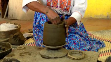 Potter 'ın killeri elle çömleğe dönüştürmesi, canlı bir atölyede çömlekçi çarkı olmadan geleneksel teknikleri sergilemesi.