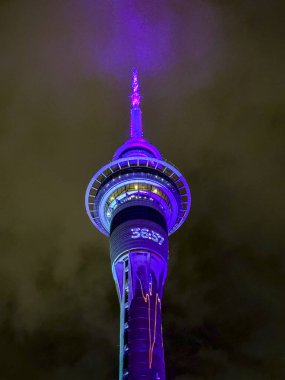 Renkli ışıklar gizemli bir gökyüzünün altındaki ikonik kuleyi süslüyor.