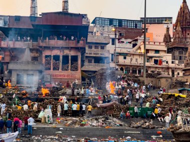 Kalabalık, geleneksel cenaze odunlarının etrafında toplandı. Ganj nehrindeki kutsal manikarnika ghat 'ında.