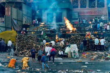 Nehir kenarındaki merdivenlerde merasim ateşiyle yakma ayinine katılan bir grup insan.