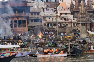 Varanasi ghatlarında hacılar ve teknelerle geleneksel Hindu yakma ayinleri.