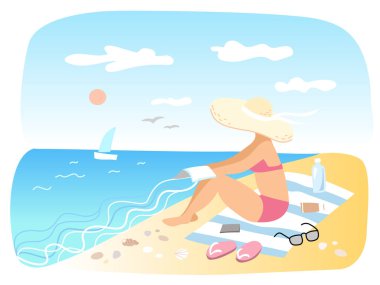 Kadın kumsalda güneşleniyor.