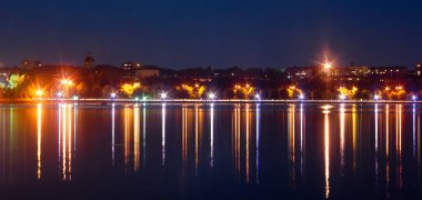 Gece kenti manzarası fener ışınları ve suda güzel bir yansıması var. Ternopil, Ukrayna