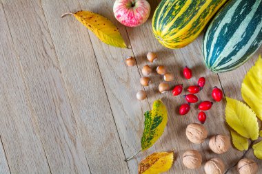 Elma, balkabağı, fındık ve yapraklar ahşap arka planda. Kopya alanı ile dekoratif sonbahar arkaplanı