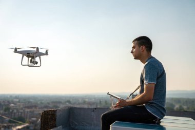 Uzaktan kumandalı insansız hava aracı uçuran genç teknisyen.