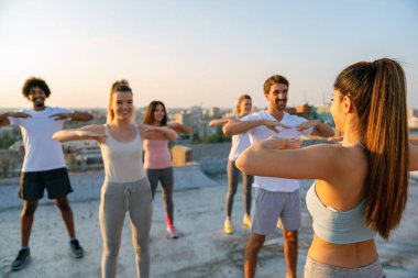 Bir grup mutlu zinde insan, dışarıda birlikte egzersiz yapıyor. Spor insanları sağlıklı yaşam tarzı konsepti.