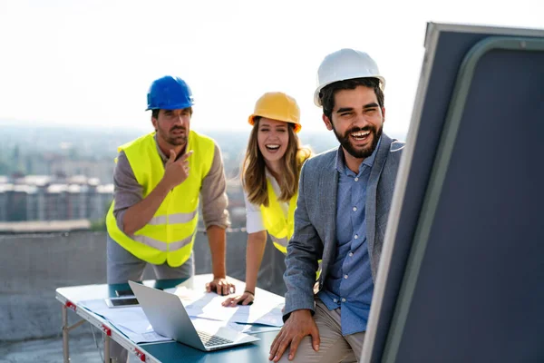 Diverse team of specialists with computer on construction site. Real estate building project with engineer, architect, business investor.