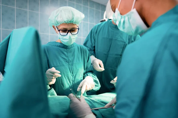 医療チームが手術を行う 病院の手術室で働く外科医のグループ — ストック写真