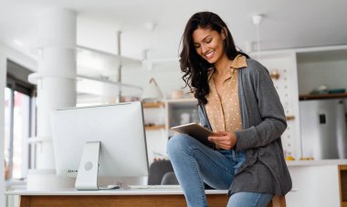 Evinde dijital tableti olan güzel bir genç kadın. Teknoloji, çevrimiçi, çalışma kavramı