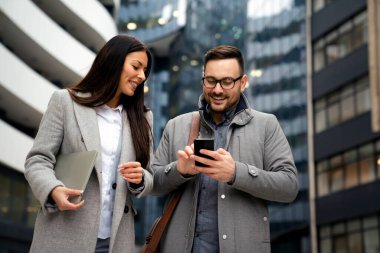 Başarılı genç iş adamları dışarıda konuşup çalışıyor. İş kadını erkek yaşam tarzı şehir konsepti.