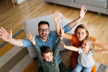 Mutlu genç aile evde eğleniyor. Ebeveynler, çocuklar mutluluk kavramını sever.