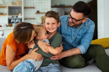 Mutlu genç aile evde eğleniyor. Ebeveynler, çocuklar mutluluk kavramını sever.