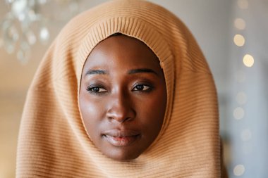 Evde başörtüsü takan güzel siyah Afrikalı Müslüman kadının portresi.