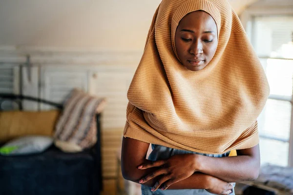 Young muslim black woman praying at home. People religion concept