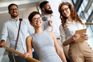 Modern ofisteki iş arkadaşları birlikte çalışıp tablet kullanıyorlar.