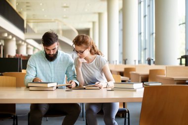 Bir kolej kütüphanesinde birlikte çalışıp çalışan bir grup başarılı öğrenci. Eğitim insanları öğrenme kavramı.
