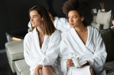 Güzel genç kadınlar spa merkezinde kahve içiyorlar.