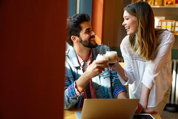 幸せな若いカップルは カフェで笑顔で座って ノートパソコンの画面を見て 喜びと時間を過ごし コーヒーを飲む — ストック写真