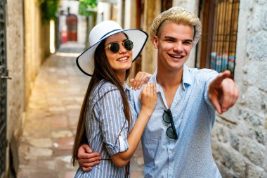 Birkaç turist tatilde şehir caddesinde yürürken eğleniyor. Mutlu arkadaşlar tatilde birlikte gülüyorlar. İnsanlar ve tatil kavramı