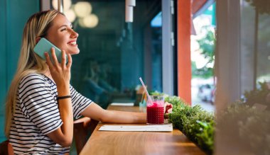Akıllı telefon kullanan mutlu genç bir kadının portresi. İnsanlar cep telefonu bağlantısı çalışma kavramı