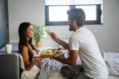 Man bringing the breakfast to his wife in bed. People, couple, love, food concept