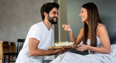 Man bringing the breakfast to his wife in bed. People, couple, love, food concept