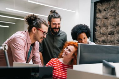 Çeşitli iş adamlarından oluşan gülümseyen bir grup birlikte evrak işleriyle uğraşıyorlar ve şirket ofisinde çalışıyorlar. İş takım çalışması konsepti.