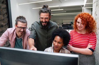 Çeşitli iş adamlarından oluşan gülümseyen bir grup birlikte evrak işleriyle uğraşıyorlar ve şirket ofisinde çalışıyorlar. İş takım çalışması konsepti.