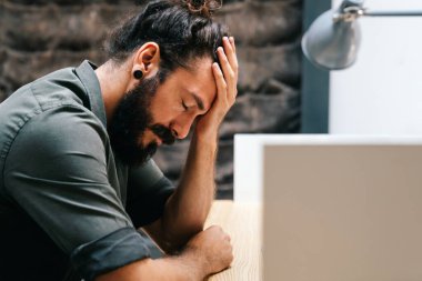 Sıkılmış, canı sıkkın iş adamı iflastan bıkmış, baş ağrısı yüzünden bitkin düşmüş, üzgün, iş yerindeki sorunlardan endişelenen siyahi ofis çalışanı.