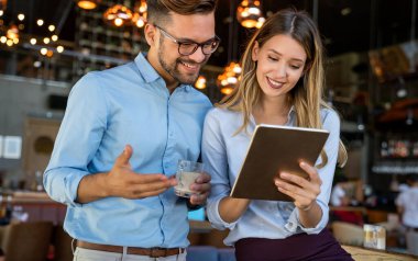 Genç iş adamları işyerinde çalışıyor, eğleniyor ve sohbet ediyorlar.