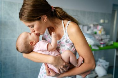 Hastanenin arka planında bebeğiyle güzel bir annenin portresi. Sağlık ve tıbbi aile yaşam tarzı kavramını seviyor