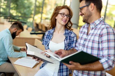 Öğrenciler kütüphanede okuyor. Gençler birlikte zaman geçirip birlikte öğreniyor..