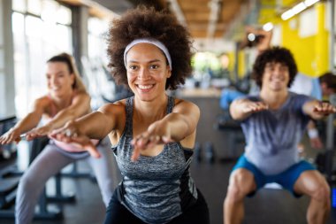 Fitness, sport, people and lifestyle concept. Group of smiling people exercising together in gym or studio clipart