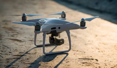 Drone with camera close up on the grey background. Preparation quadrocopter to start flying outdoor.