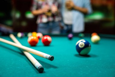 Barda bilardo oynarken eğlenen genç çiftin portresi.