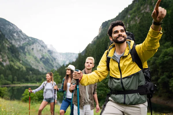 Group of friends with backpacks doing trekking excursion on mountain. Trekker, sport, hike and travel concept