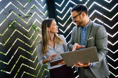 Başarılı iş arkadaşlarının portresi ofiste birlikte çalışıyor, gülümsüyor. İş adamları takım çalışması kavramı.