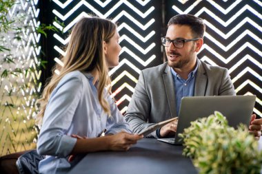 İş projesi ekibi şirket ofisindeki toplantı odasında birlikte çalışıyor.