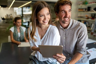 Gülümseyen çeşitli meslektaşlar toplantı odasında toplanmış mali istatistikleri tartışıyorlar. Mutlu çok ırklı iş arkadaşları ofis toplantılarında işbirliği yaparken eğleniyorlar. Takım çalışması konsepti.
