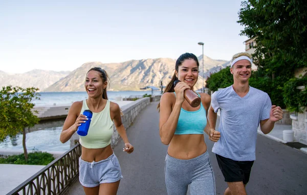 Group of cheerful fit fitness friends team exercising together outdoor. Sport people fitness health concept