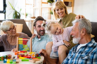 Neşeli, çoklu kuşak bir aile evde birlikte vakit geçirirken eğleniyor. İnsanların mutluluk kavramı.
