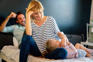 Genç gülümseyen aile evde şakacı oluyor. İnsanlar ebeveyn çocuk mutluluk kavramı.