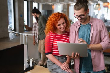 Genç girişimci iş adamları işyerinde eğleniyor, çalışıyor ve sohbet ediyorlar. İş teknolojisi kavramı